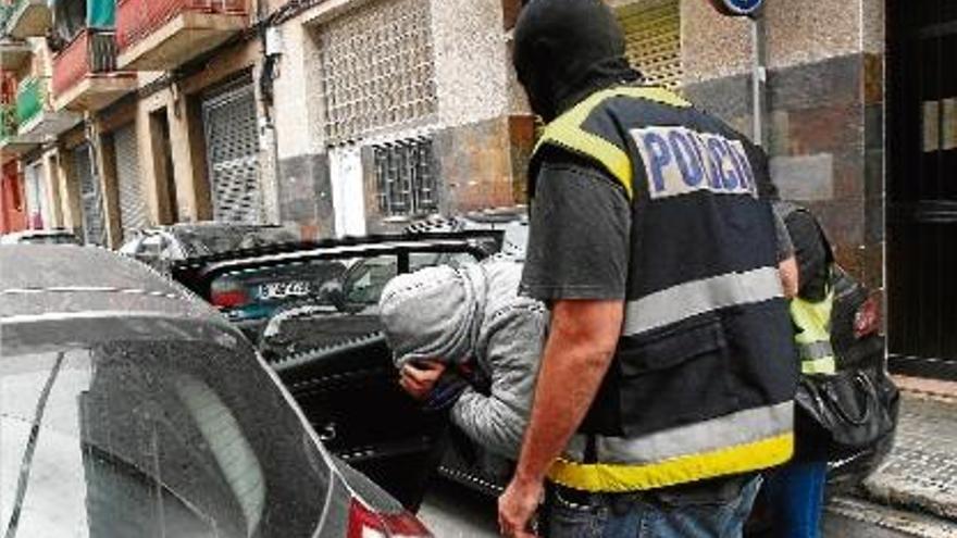 Agents de la policia introdueixen el detingut al cotxe.