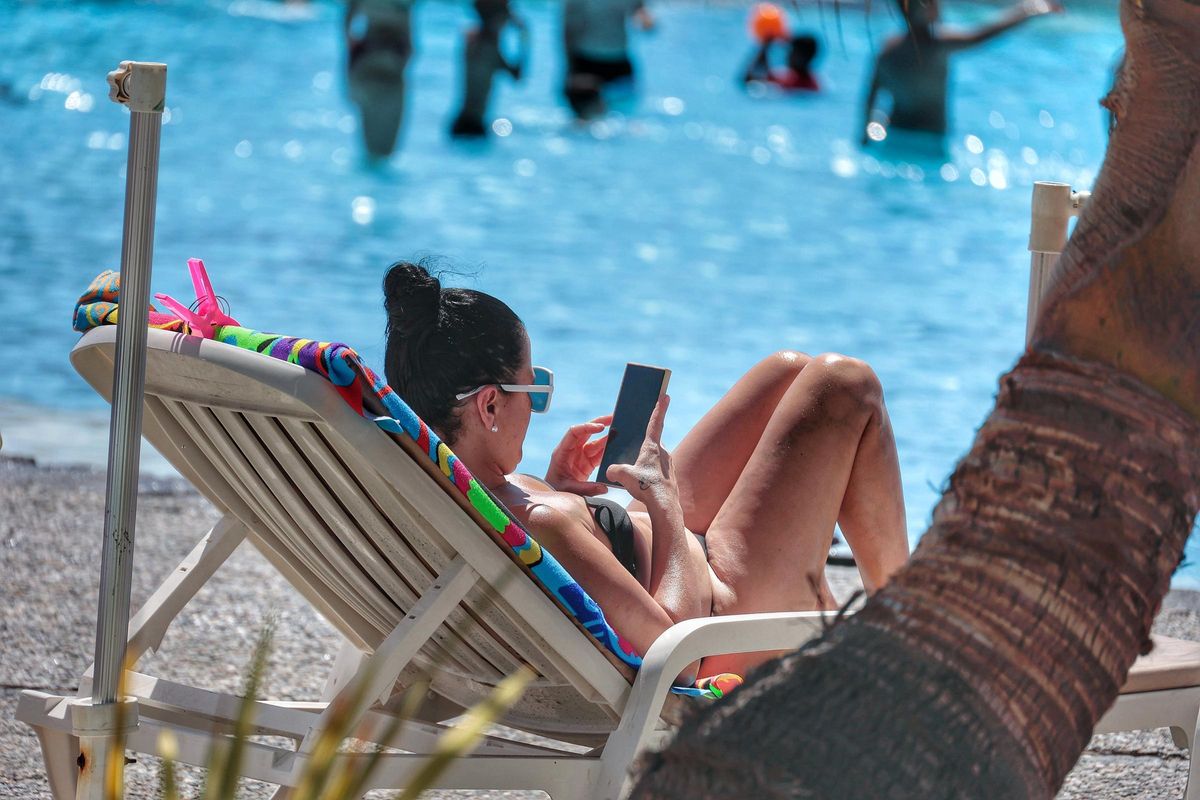 Una usuaria disfruta de la lectura en el Parque Marítimo.