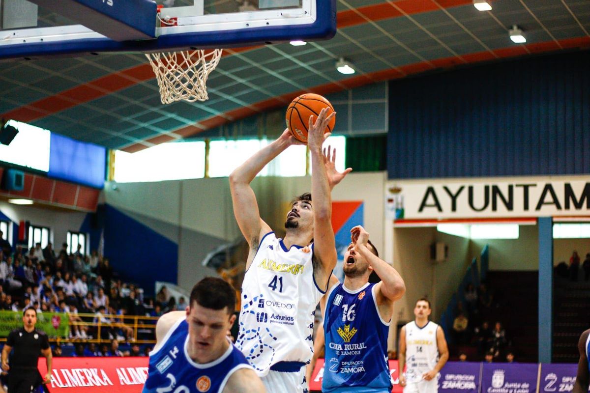 El jugador del Alimerka Oviedo Robert Cosialls trata de anotar con Nikic detrás. BALONCESTO