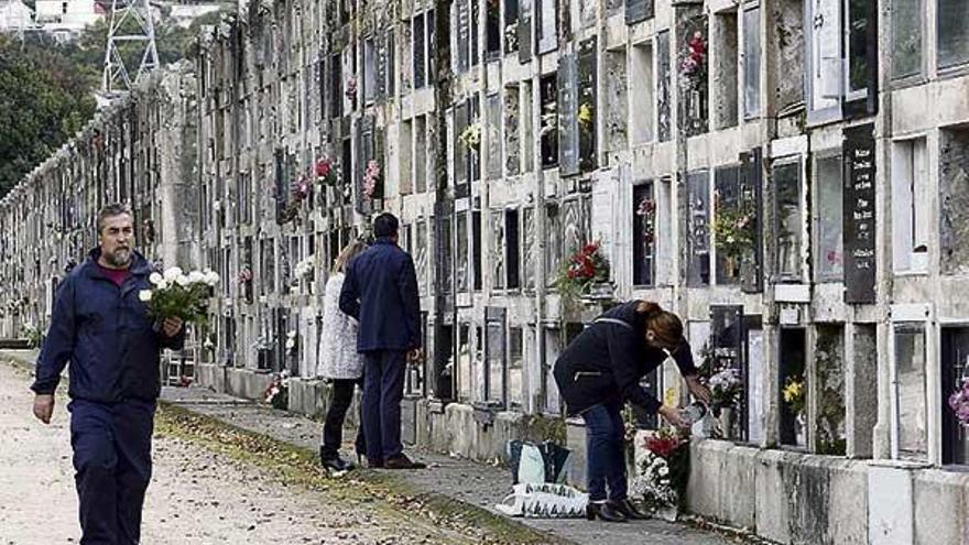 Un grupo de personas adecentando nichos ayer en el cementerio de Pereiró.  // M. G. Brea