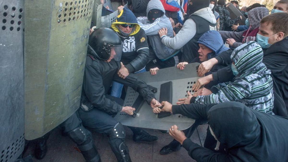 Activistas prorrusos se enfrentan a los policías, que custodian el edificio de la Administración en Donetsk (Ucrania).