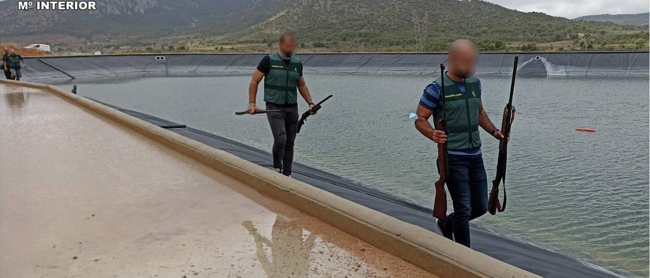 Los agentes con las armas recuperadas en el embalse de Monóvar.