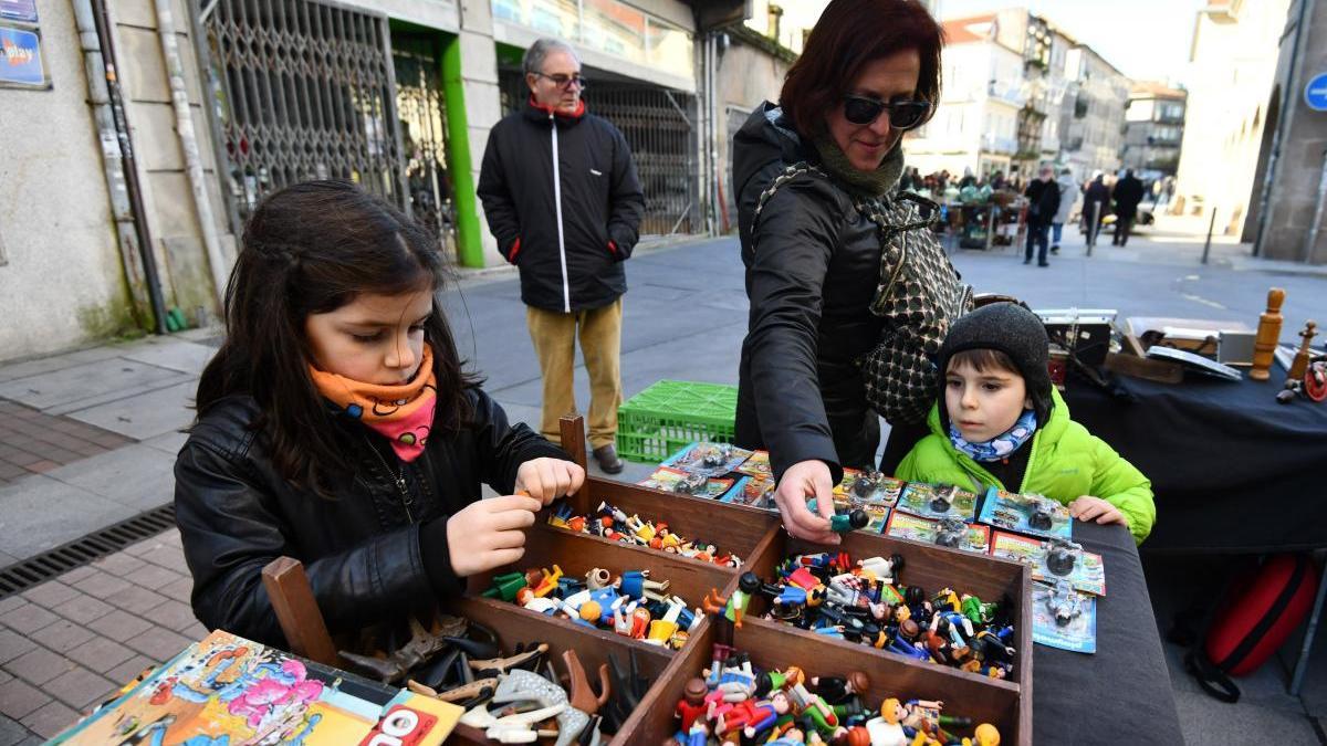 Clientes de distintas edades en un puesto del mercadillo. // G. Santos