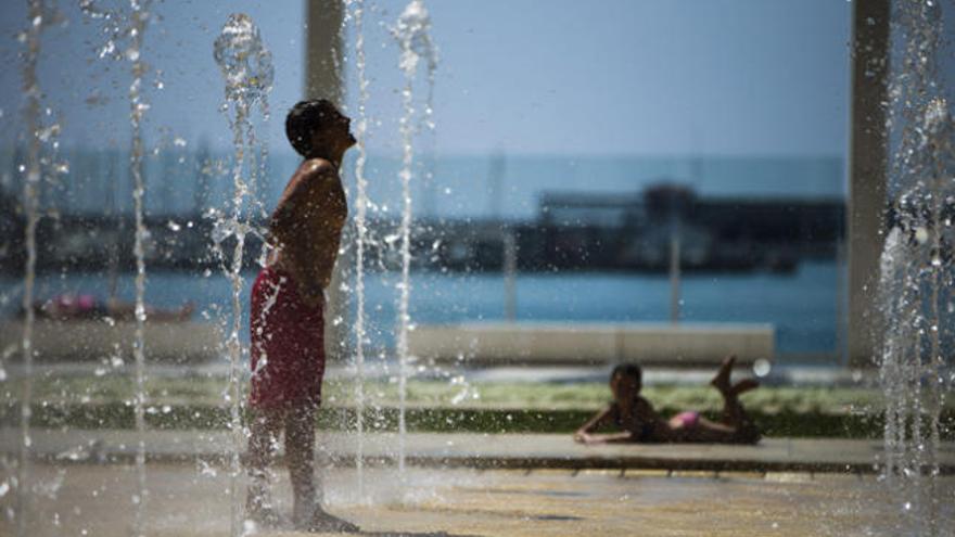 Un niño se refresca en plena ola de calor.