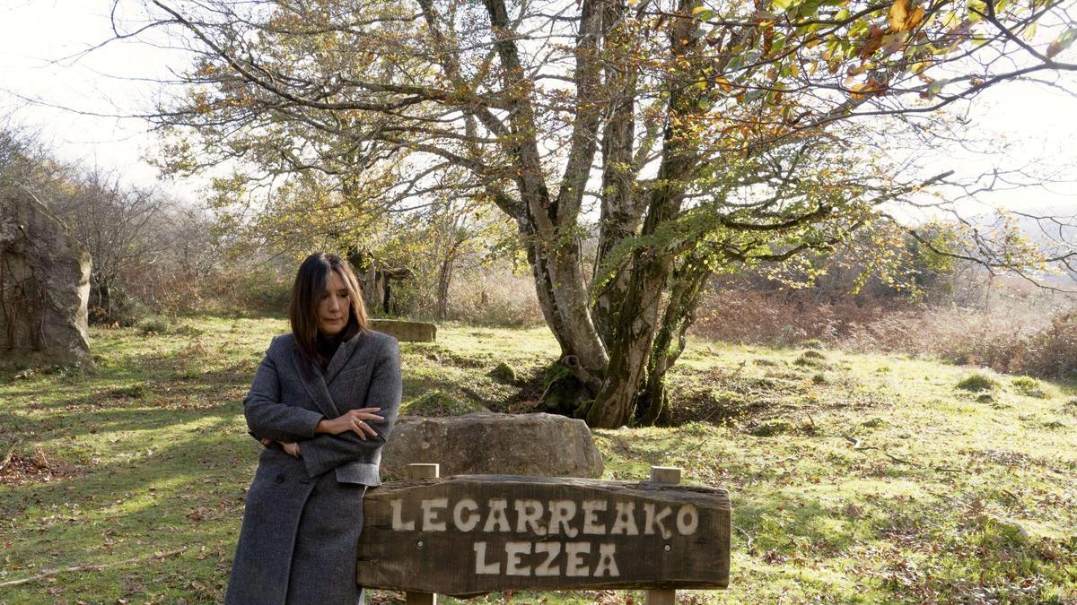 Dolores Redondo, con el árbol bajo el que se abre la sima de Legarrea, escenario de crímenes, en Navarra.