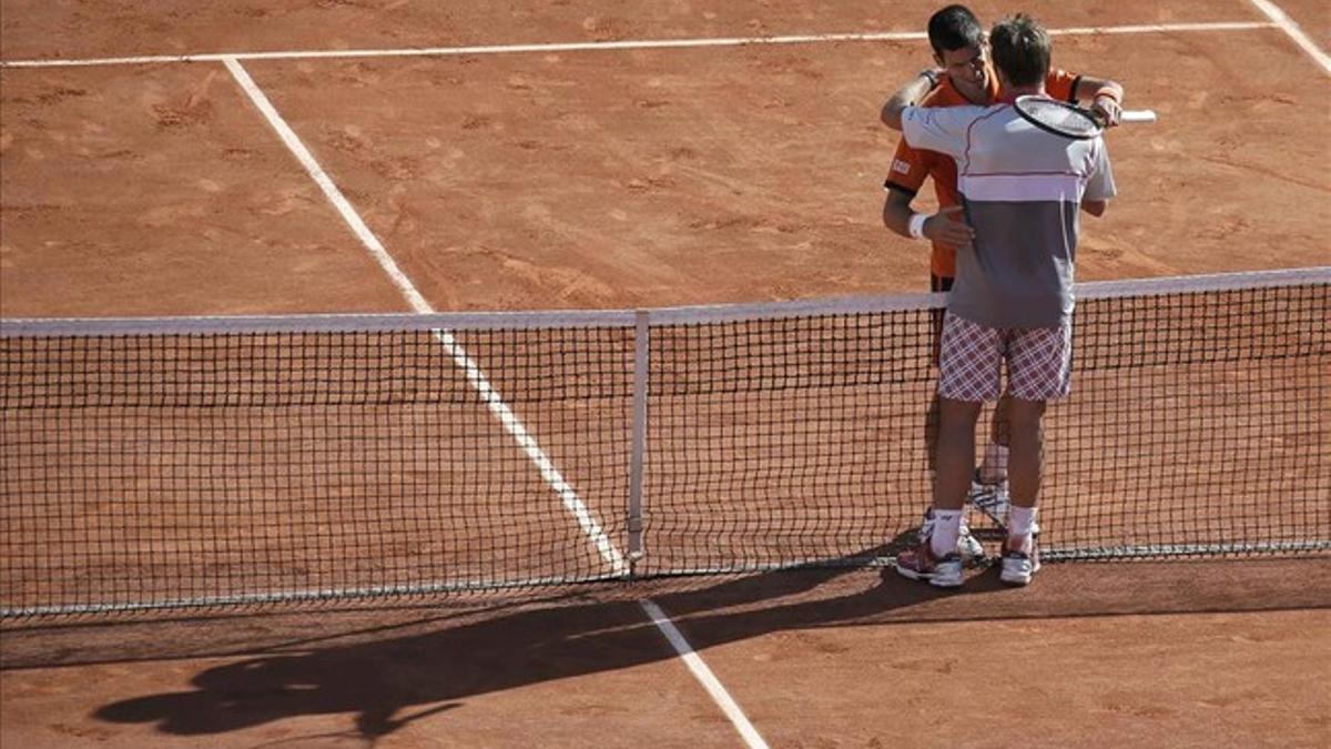 Djokovic y Wawrinka se abrazan en la pista central de Roland Garros tras la final.