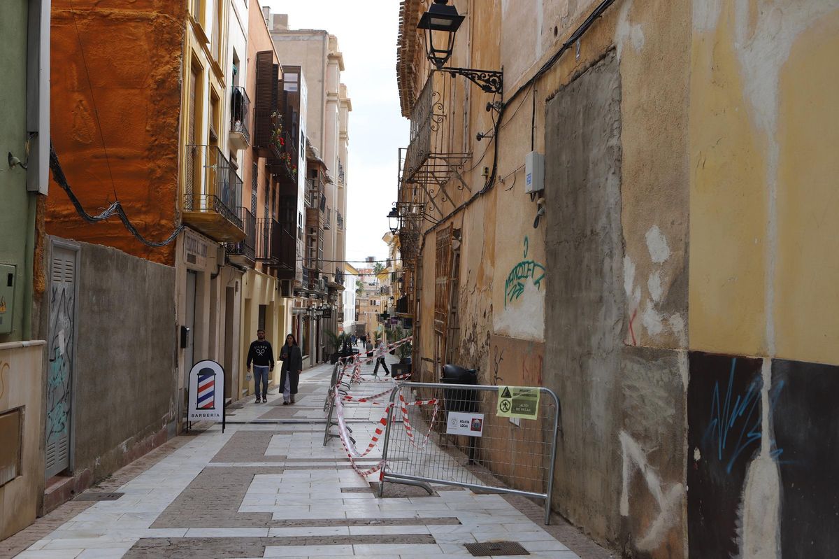 Una pareja pasa junto a una casa abandonada en Pío XII.