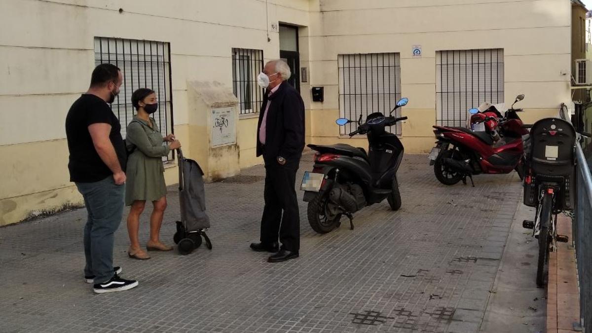 Dos de los propietarios charlan con el administrador de fincas del edificio.