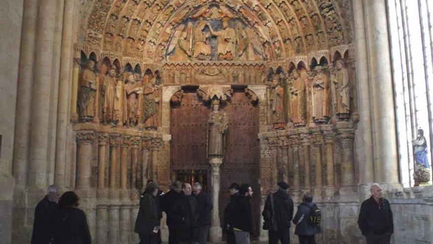 Turistas admiran el Pórtico de la Majestad en su recorrido por el interior de La Colegiata. Foto