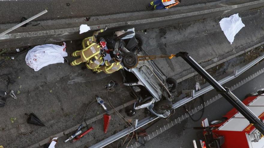 Los bomberos trabajan en el mortal accidente de la AP-9, en Teis