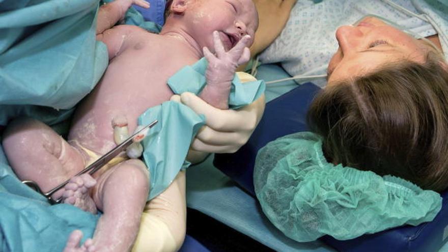 Un bebé recién nacido, junto a su madre.