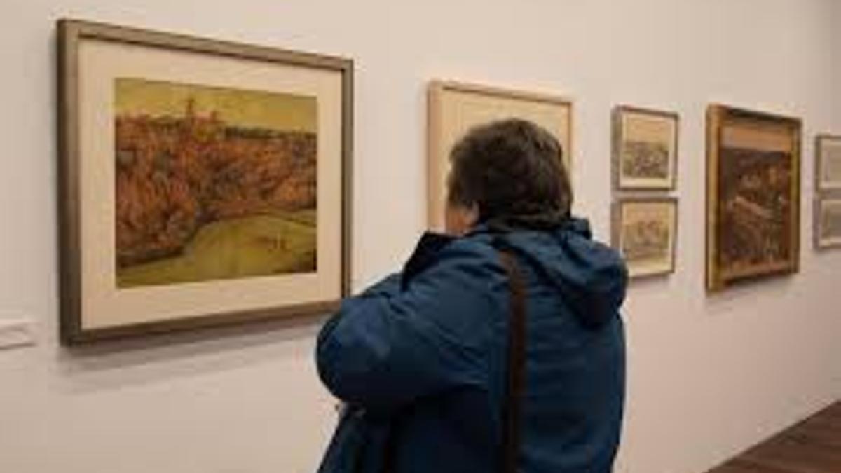 Una mujer observa algunas de las obras de Antonio Pedrero exhibidas en la sala de exposiciones del Museo de Zamora.