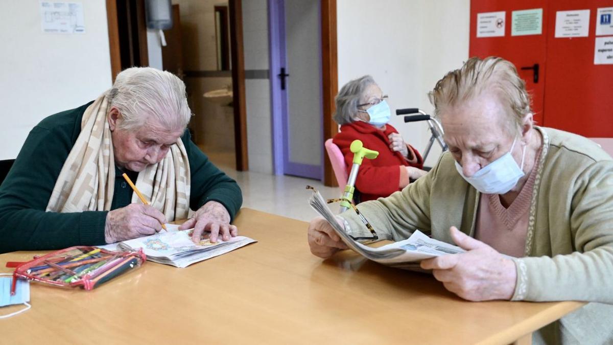 Dos mujeres se entretienen pintando y leyendo la prensa.   | // RAFA VÁZQUEZ