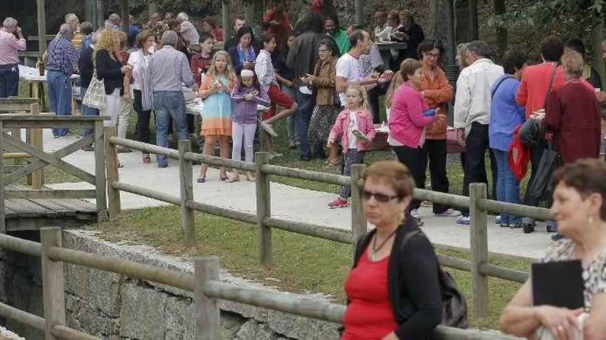 Los asistentes a la Festa do Socio degustan las sardinas en los espacios verdes que rodean el centro cultural.