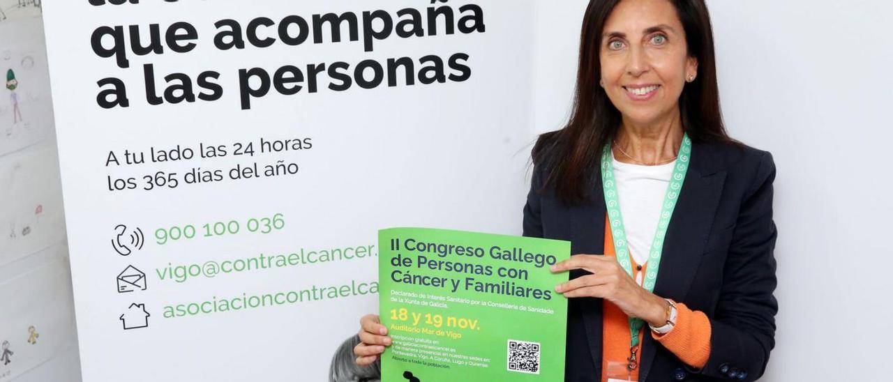Elisa Alonso, una de las organizadoras del evento en Vigo, mostrando el cartel del congreso.