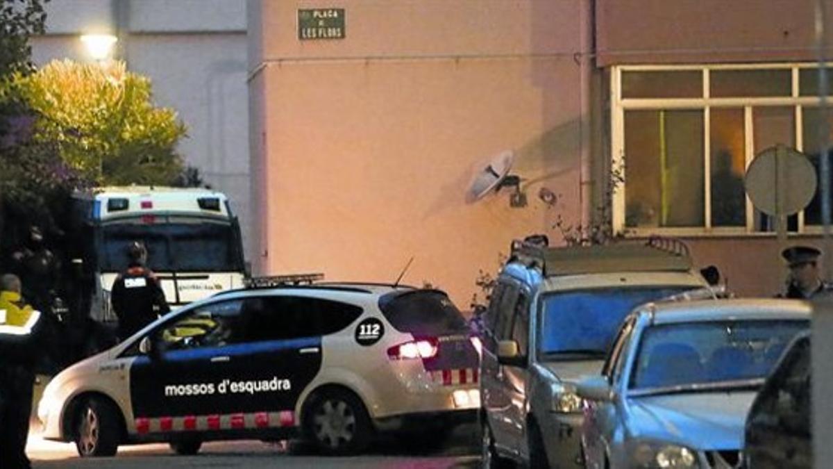 Un coche policial se lleva al detenido por el crimen de ayer en Sant Pere Pescador.