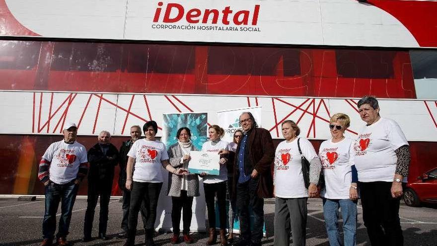 Afectados de iDental, recogiendo ayer el premio a la entrada de la antigua sede de la empresa en Tremañes.