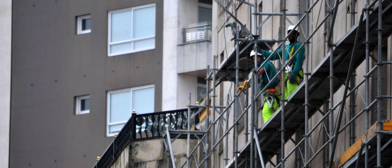 Dos trabajadores del sector de la construcción en un andamio, en una obra en Vilagarcía. |  // IÑAKI ABELLA