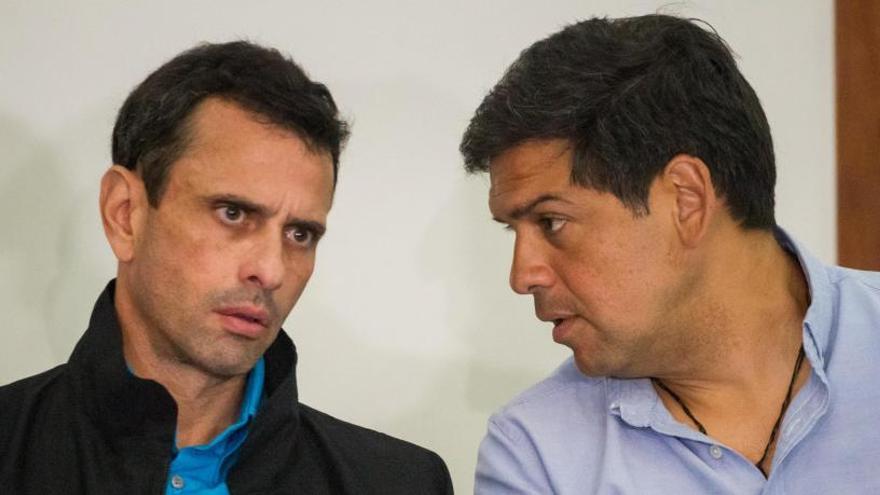 El gobernador saliente del estado Miranda, Henrique Capriles (i), conversa con el candidato Carlos Ocariz.