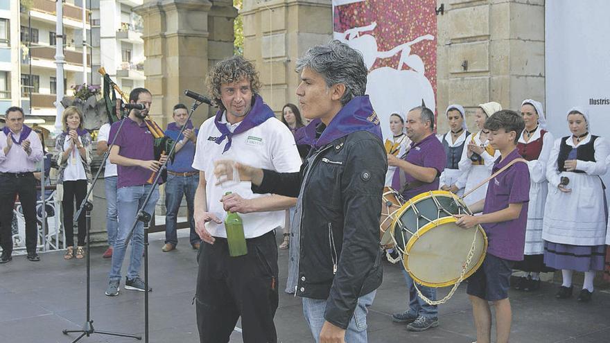 El hostelero Guti Rodríguez observa a Nando Argüeros, al que escanció el primer culín del Festival de la Sidra maliayés.