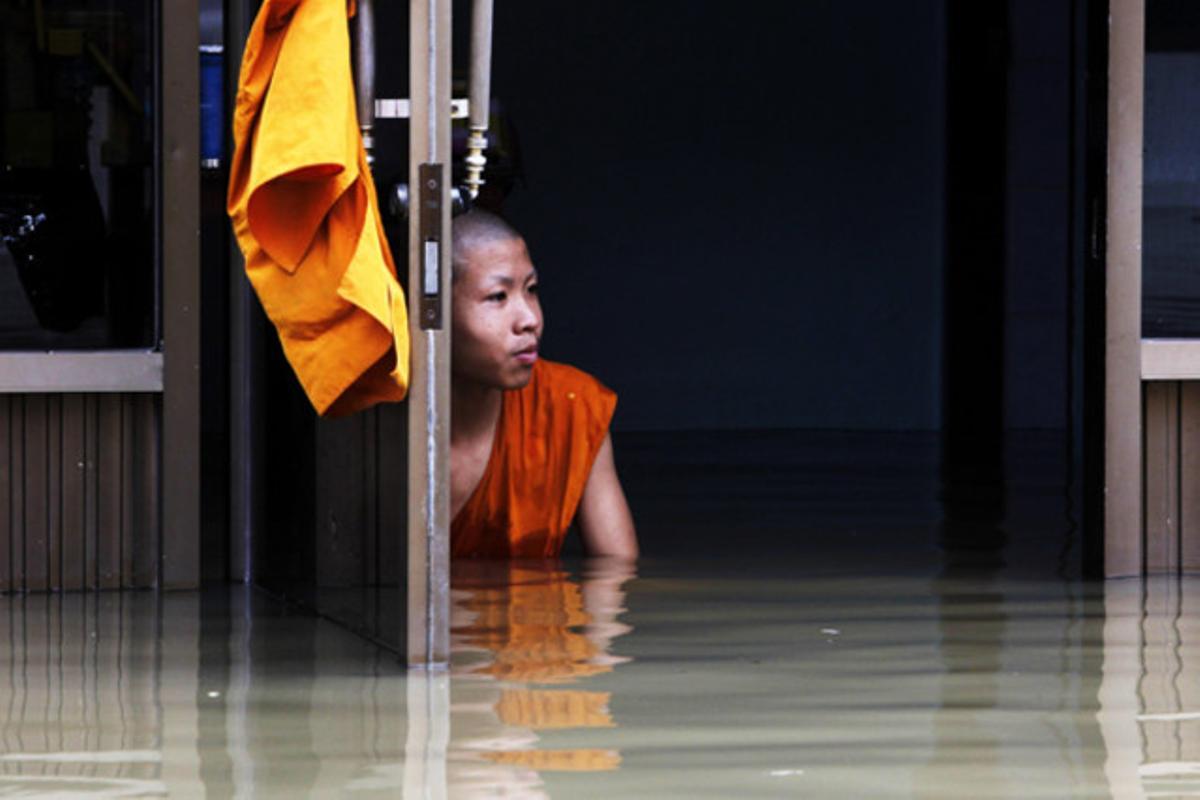 Un novici budista, assegut en un temple inundat durant els monsons a la província d’Ang Thong (Tailàndia).