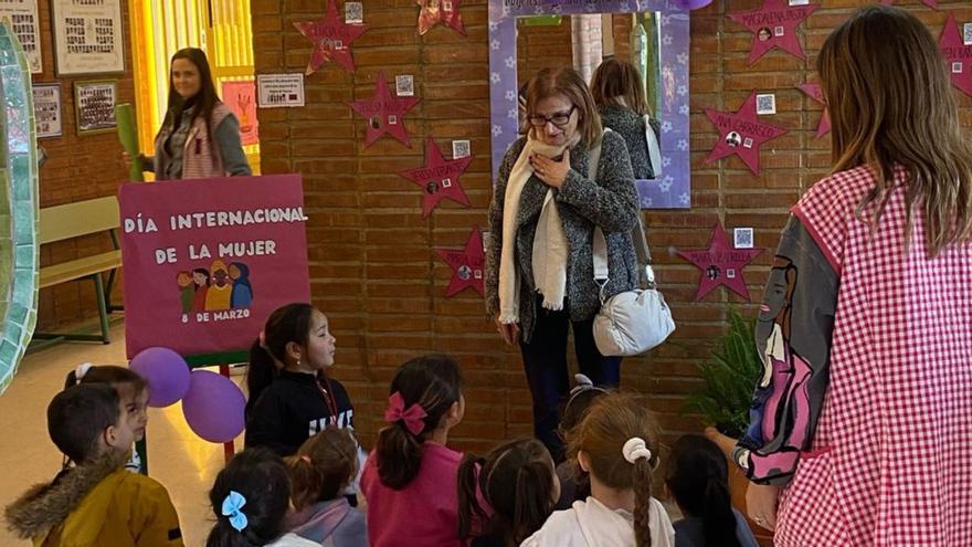 Alumnos y docentes en el ‘pasillo de la fama’ creado en el centro durante la visita de una de las mujeres estudiadas, Magdalena Pastor. | L.O.