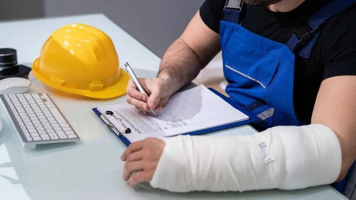 Un trabajador con el brazo escayolado sigue trabajando.