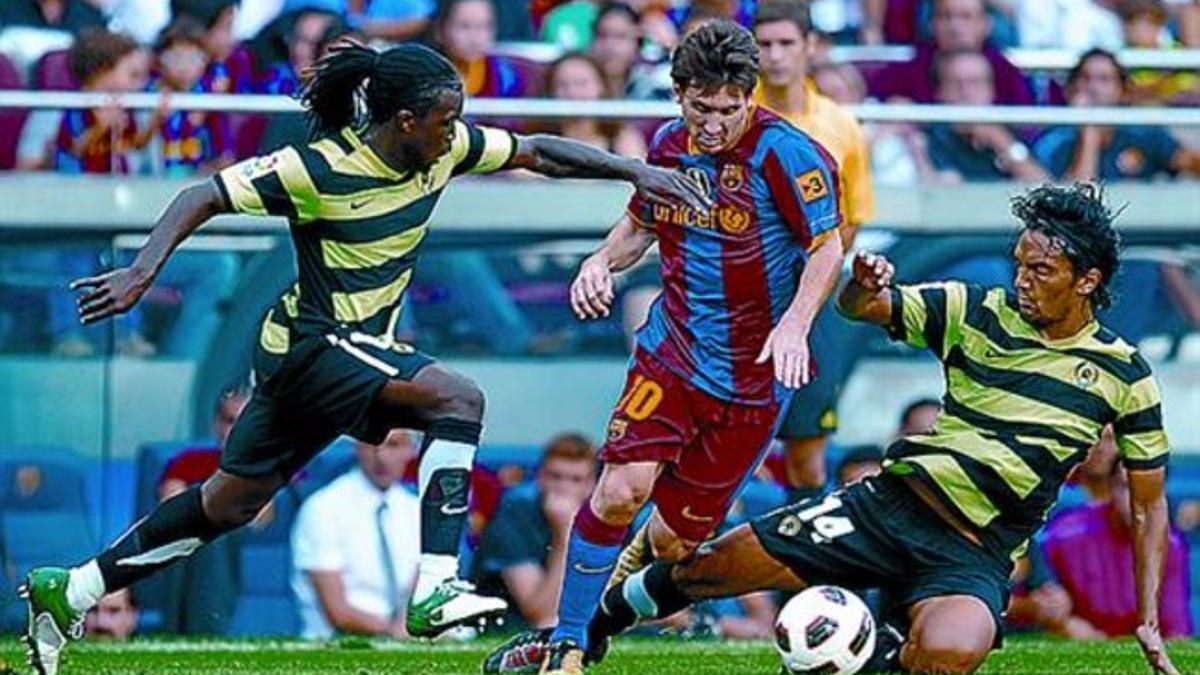 Messi trata de superar a Drenthe y Aguilar.