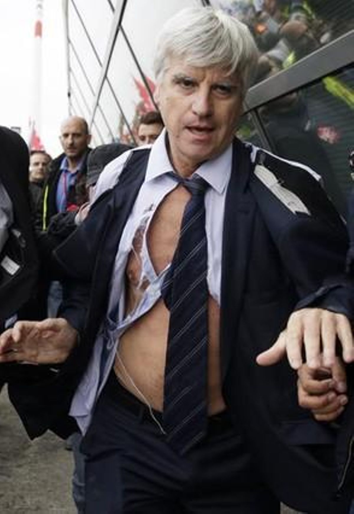 El director de Air France en Orly, Pierre Plissonnier, casi sin camisa, escapa de los manifestantes ayudado por los agentes de seguridad, después de que cientos de empleados entraran en las oficinas centrales de Air France.