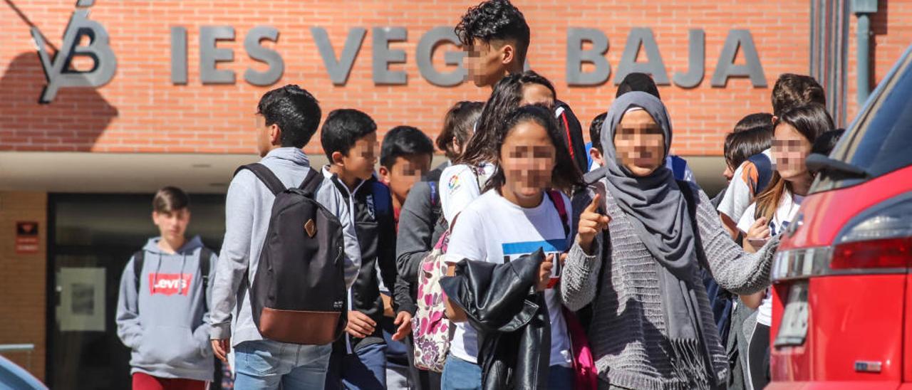 Alumnos del IES Vega Baja de Callosa de Segura, entre ellos varios extranjeros, salen ayer del centro tras terminar las clases.