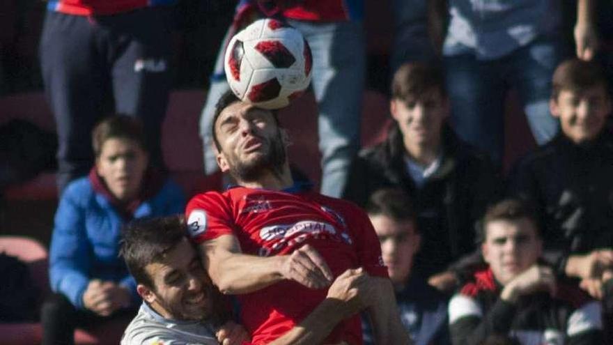 Josu disputa un balón aéreo con Germán, del Ourense CF, en O Couto. // Brais Lorenzo