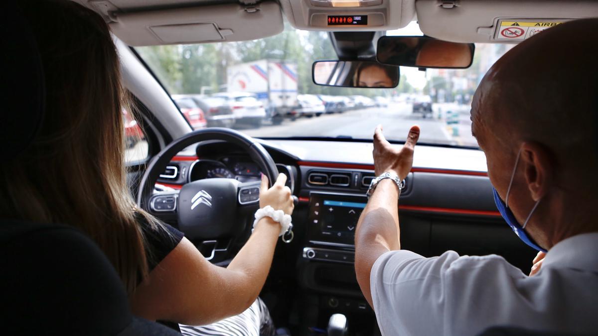 Una alumna recibe formación práctica en el coche de una autoescuela.