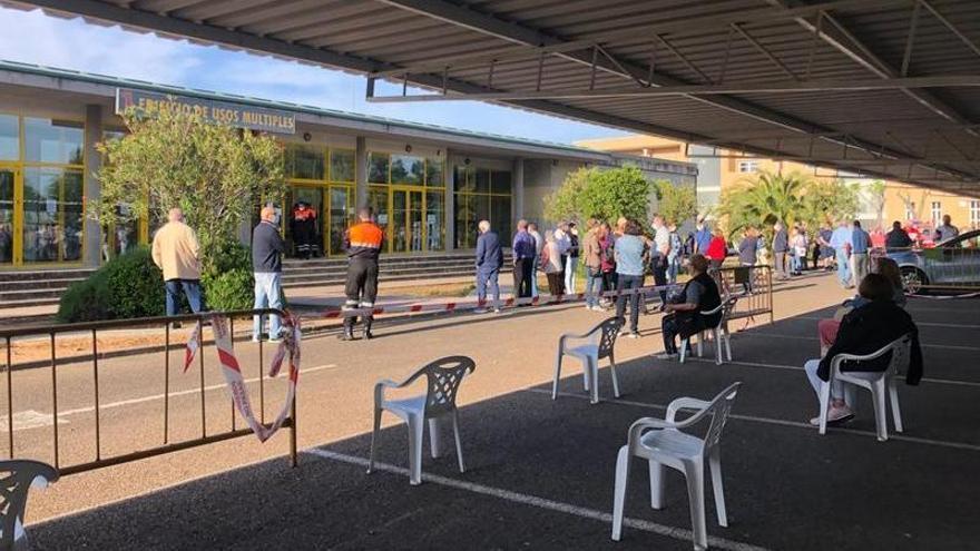 Gente esperando de pie y sentada pocos minutos antes de que el personal sanitario comenzase a inocular dosis.