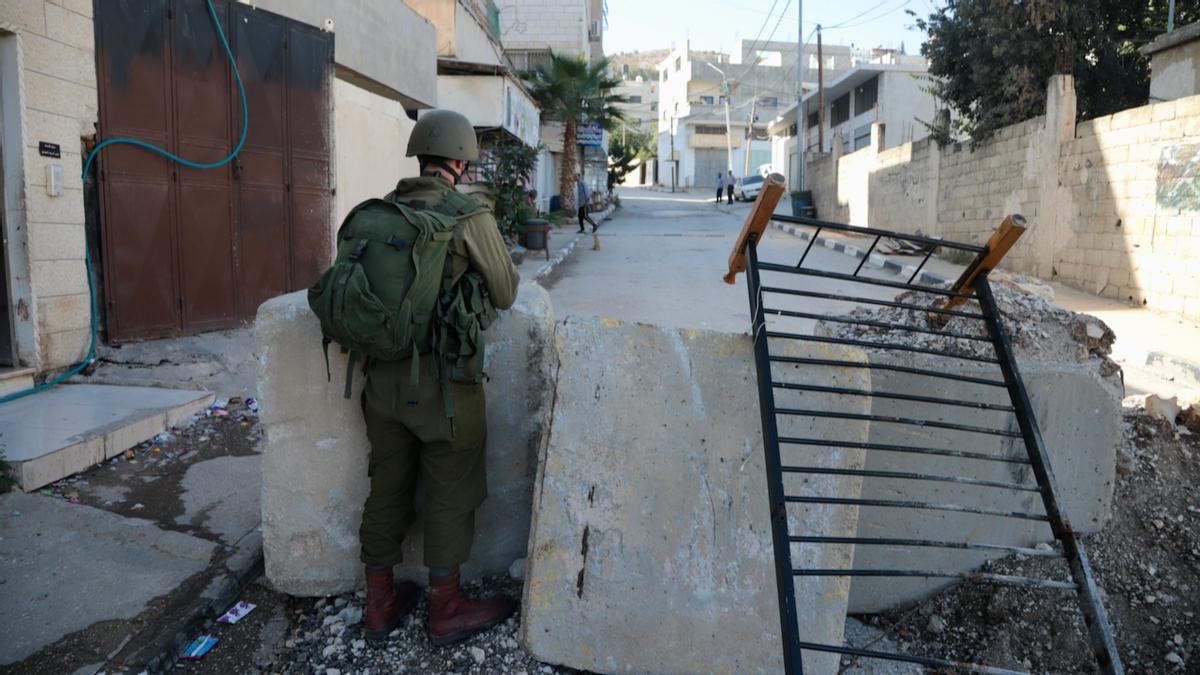 Un soldado israelí vigila una de las calles de Huwara, en Cisjordania, cortada para impedir a sus habitantes transitar por su principal arteria comercial.