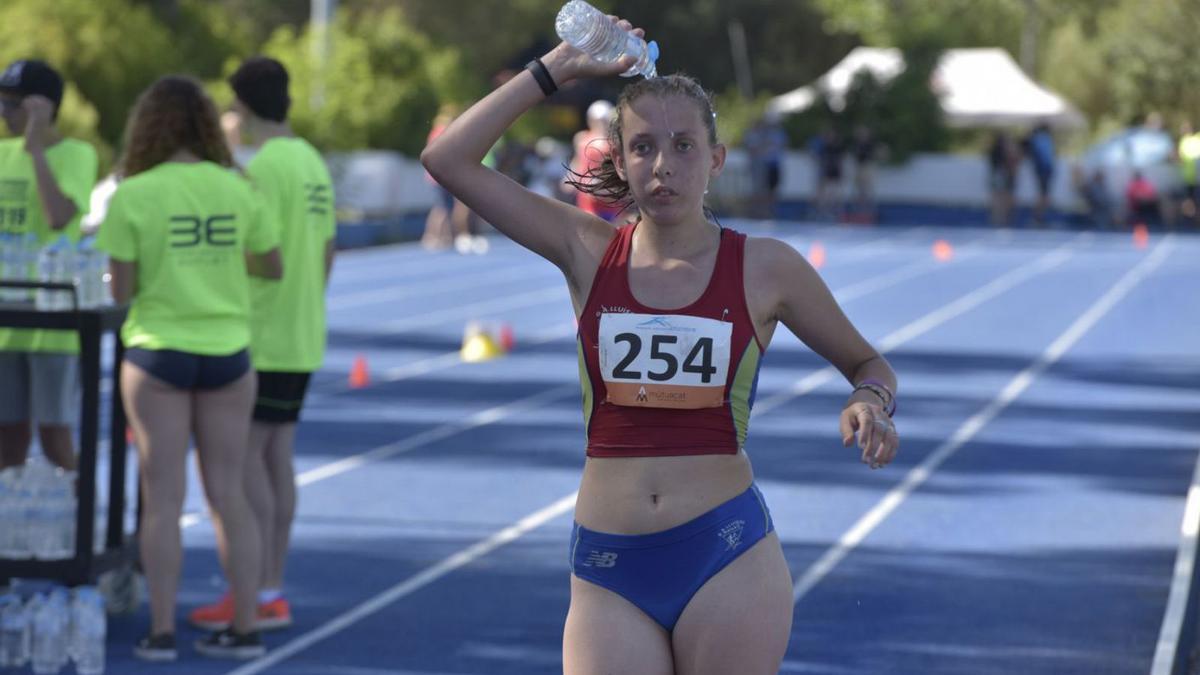 Una atleta es refresca durant la prova dels 5.000 metres marxa | OSCAR BAYONA