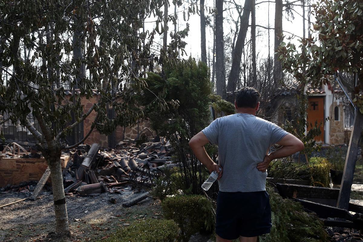 Un hombre contempla los restos de los incendios que han arrasado la zona norte de Atenas.