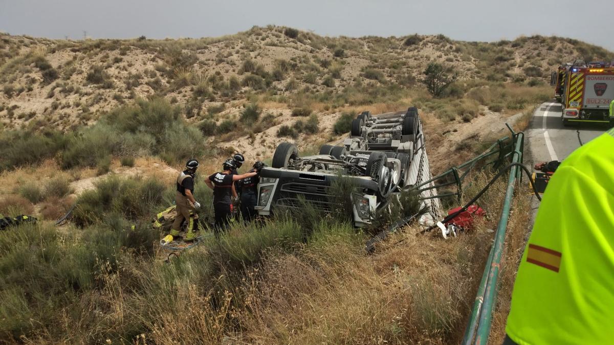 Los bomberos intentan excarcelar al conductor, que permanecía atrapado en el interior de la cabina.