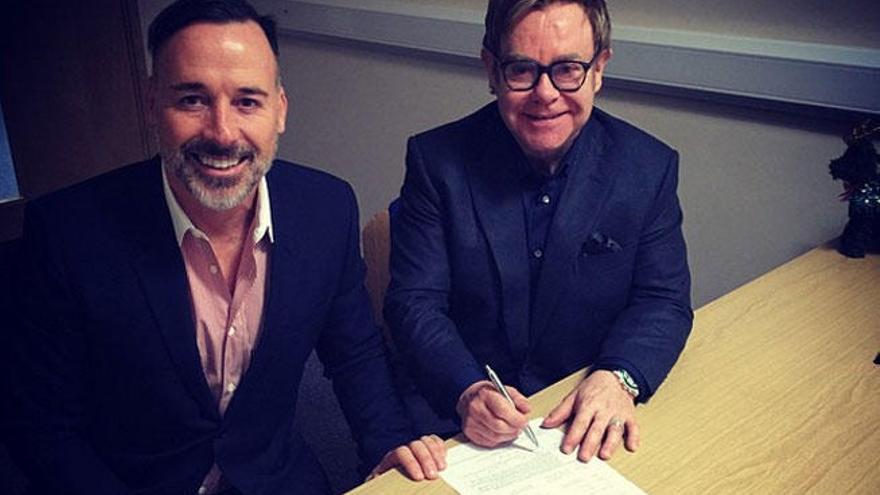 Elton John y David Furnish firmando los papeles