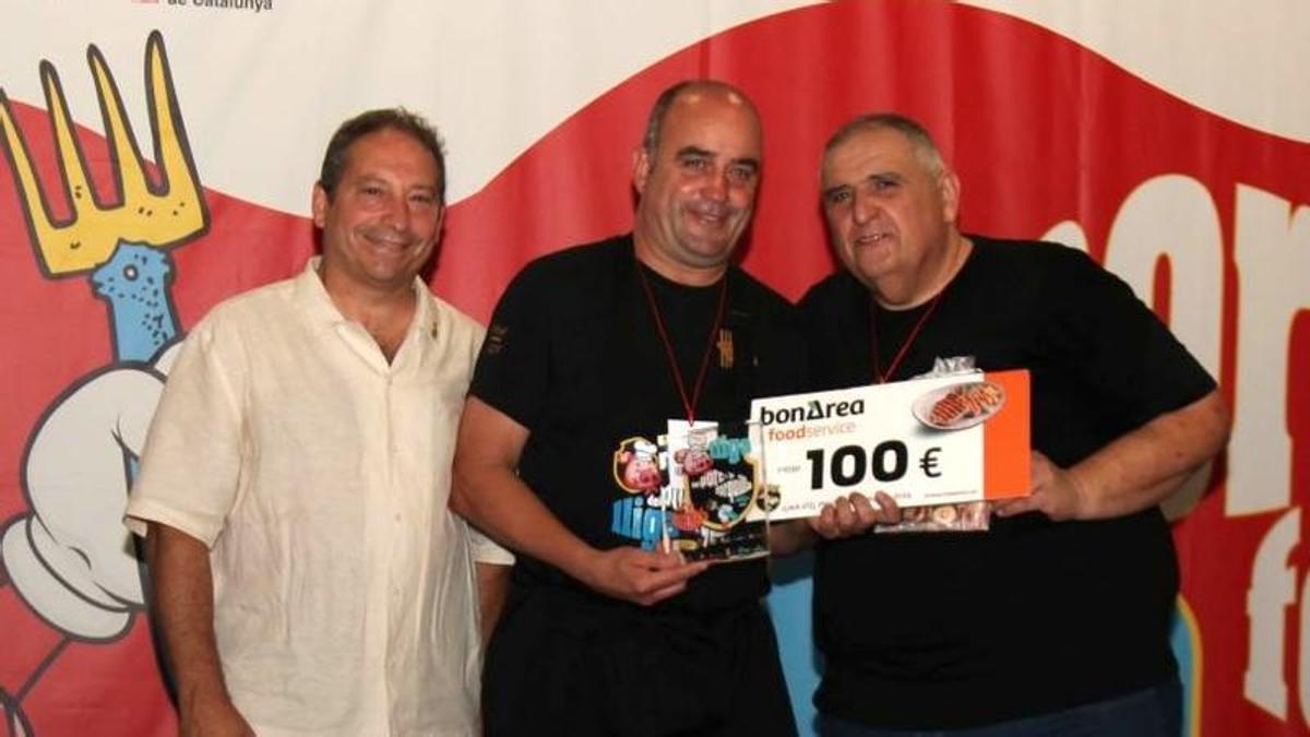 Jordi Mascort, de Can Mascort (al centre de la imatge), rep el guardó que l'acredita com a guanyador de la semifinal gironina de la Lliga del Porc i la Forquilla.