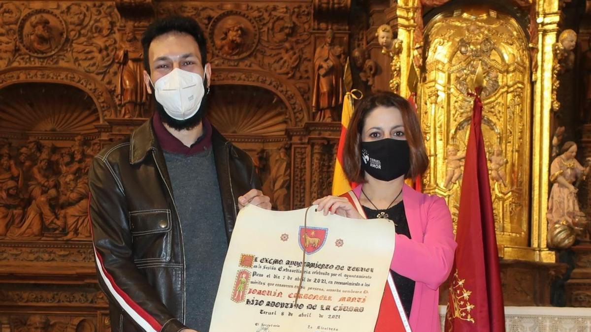 Alejandro, hijo de Carbonell, recibe el título de hijo adoptivo par su padre, de manos de la alcaldesa, Emma Buj.