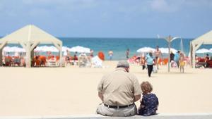 Un abuelo con su nieta en la playa. 