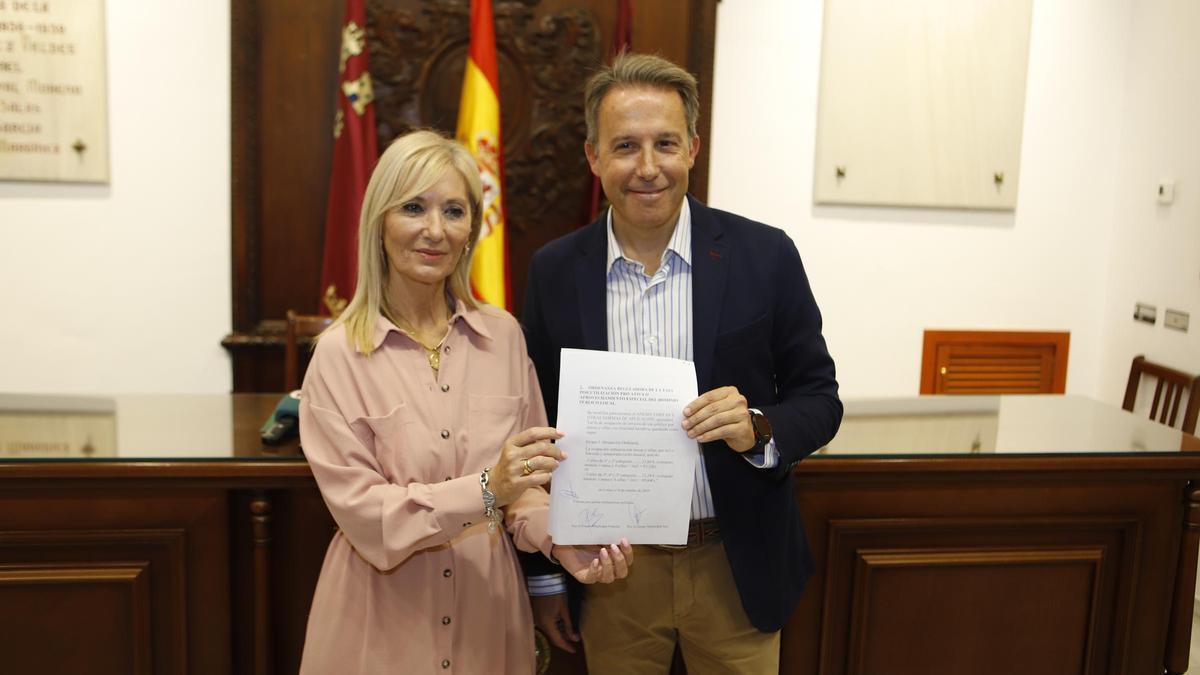 Gil y Menduiña muestran el documento con los acuerdos alcanzados.