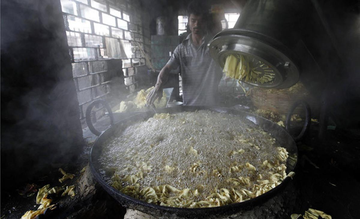 Un treballador a la cuina d’un restaurant de l’Índia. Un treballador a la cuina d’un restaurant de l’Índia.