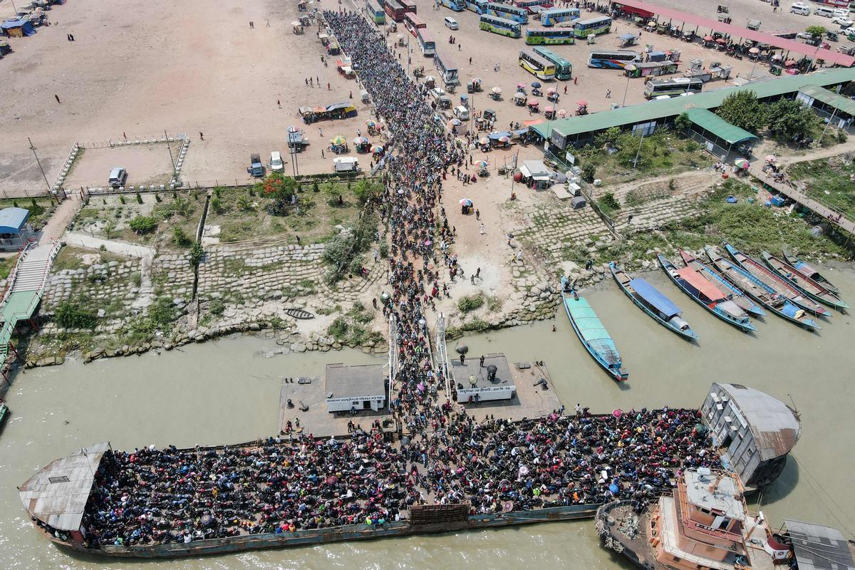 Gente haciendo cola para abordar un ferry que los llevará a sus lugares de origen para celebrar Eid al-Fitr, que marca el final de la fiesta sagrada musulmana del Ramadán en Dhaka el 1 de mayo de 2022.