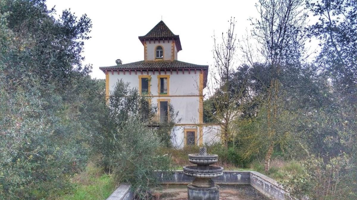 La casa imponent amb zones de bosc i ribera