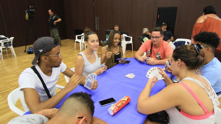 Un grupo de jóvenes desalojados juega a cartas en el Espai Baladre de la playa de Gandia.