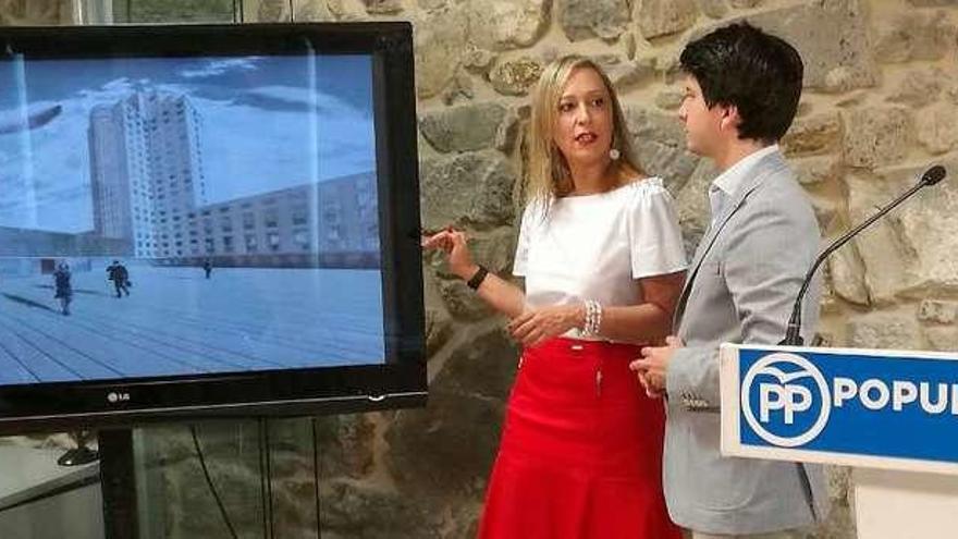 Elena Muñoz y Diego Gago junto a una recreación virtual de la futura plaza de la Ciudad de la Justicia.