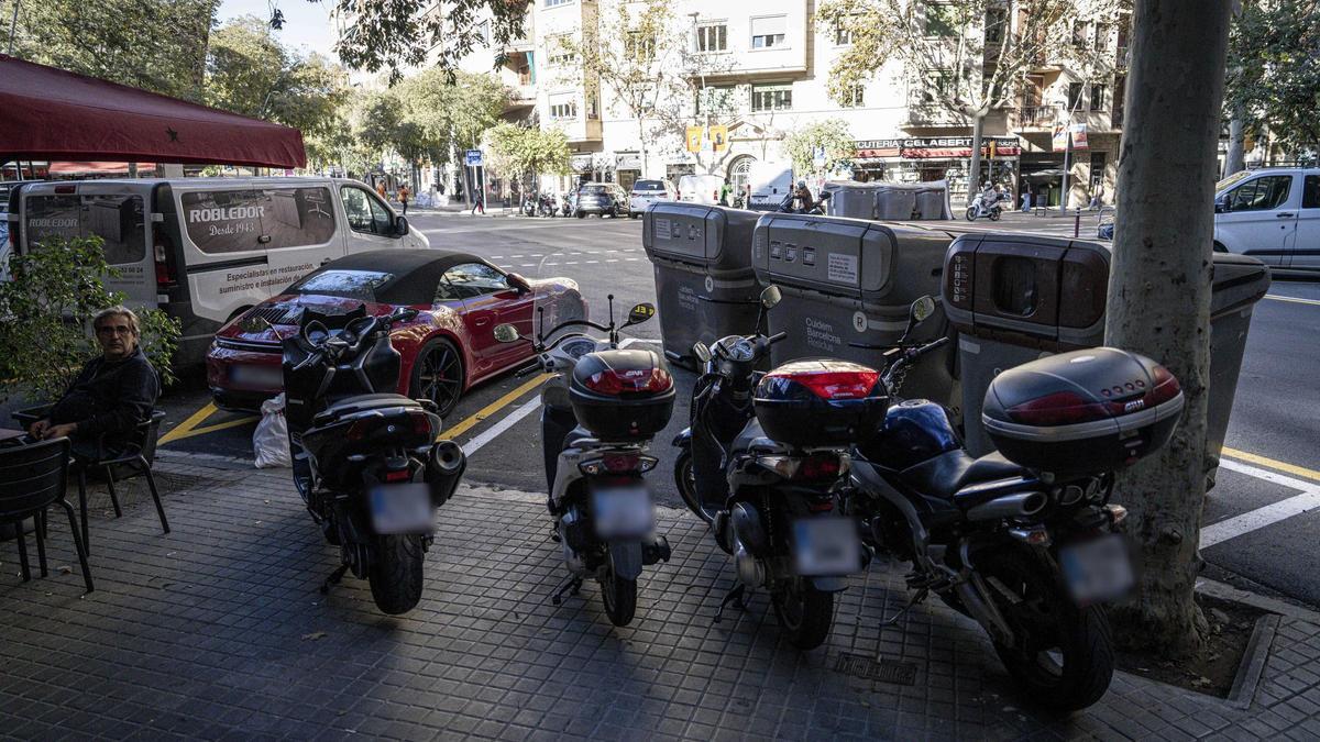 Motos mal aparcadas impidiendo el acceso a los contenedores de basura en la esquerra de l'Eixample.