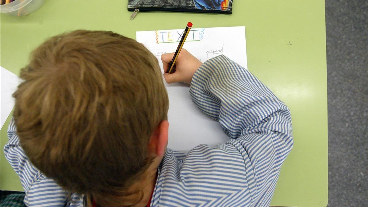 Un escolar aprende a escribir en un centro de Barcelona.