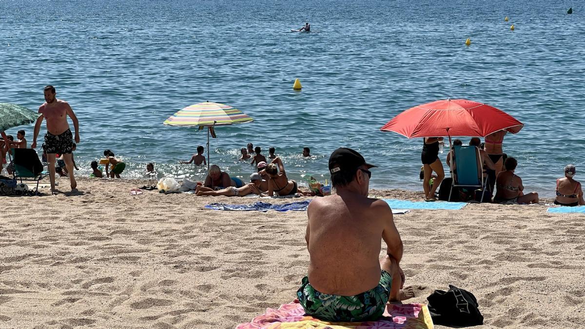 Un hombre toma el sol en la Platja dels Pescadors de Pineda de Mar